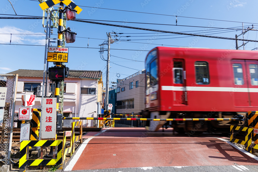 遮断機のある踏切を通過する赤い通勤電車 Stock Photo | Adobe Stock