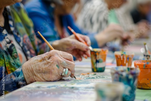 Senior's Hand Painting in Art Workshop, Closeup of Creativity photo