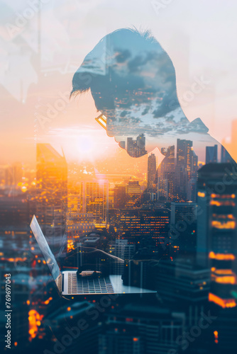 A double exposure image of a businessman using a laptop during sunrise, overlaid with a cityscape image. Concept of modern life