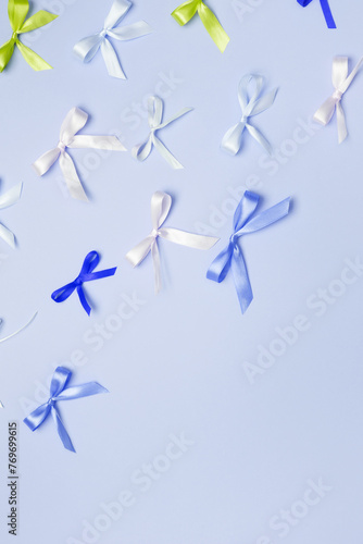 Fototapeta Naklejka Na Ścianę i Meble -  Multicolored bows on blue background. Top view, copy space