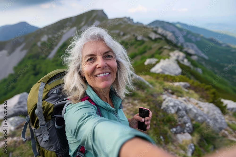 Senior woman taking a selfie on mountain