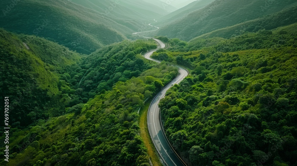 Aerial top view beautiful curve road on green forest in the rain season. Aerial top view beautiful curve road on green forest in the rain season.