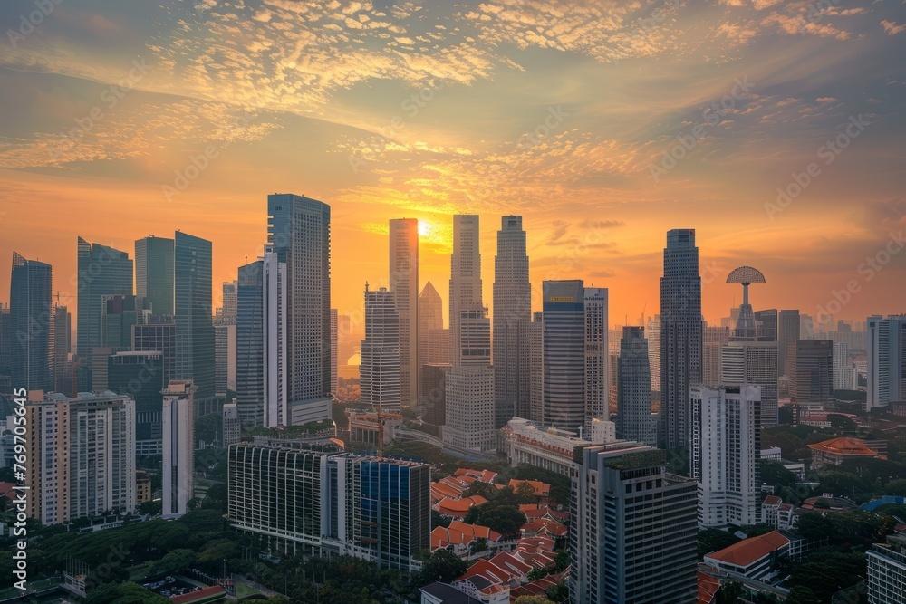 The sun is setting over a city with tall buildings, casting a warm glow on the urban landscape
