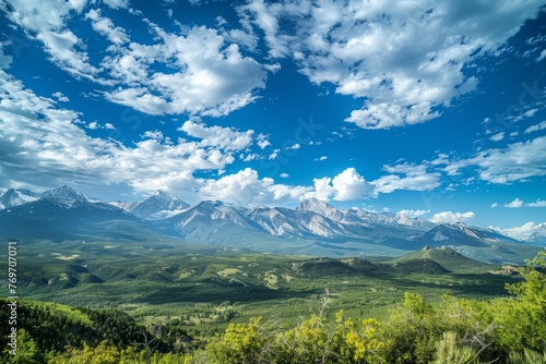 A wide-angle view of a majestic mountain range  showcasing peaks and valleys under cloudy skies