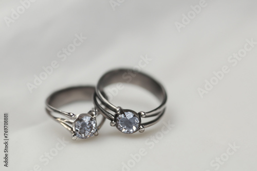silver rings. small stylish silver rings with a large stone, lie on a white table, close-up, jewelry concept