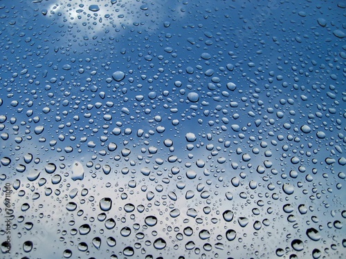Closeup of a glass window with waterdrop against blue sky