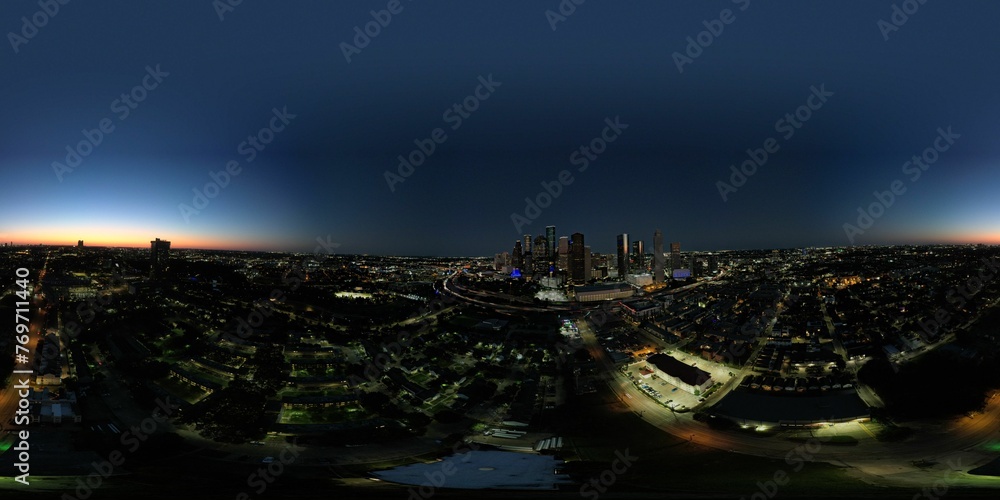 Panoramic view of the vibrant Houston skyline at night with illuminated buildings across the horizon