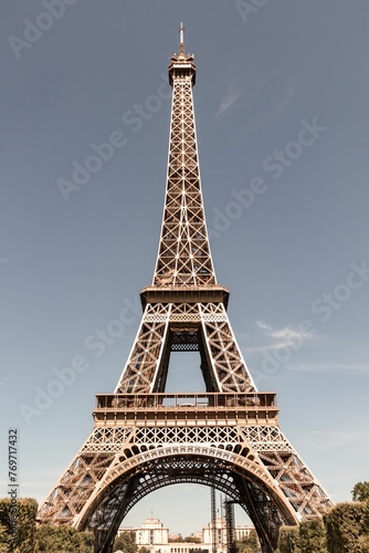 Fototapeta Naklejka Na Ścianę i Meble -  Scenic view of the iconic Eiffel Tower in Paris, France, with lush green trees