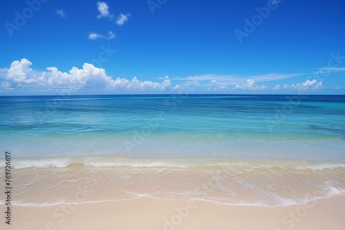 Beautiful beach scene with clear blue sky and white clouds, suitable for travel brochures, vacation advertisements, and peaceful backgrounds.