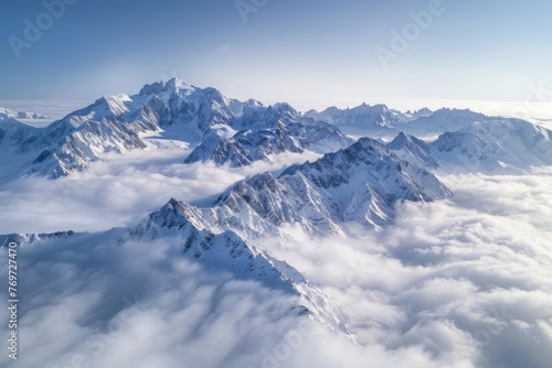 High-altitude view of jagged peaks of a snowcapped mountain range from an airplane above a sea of clouds