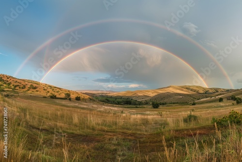 Two rainbows arch over a grassy field, displaying the full spectrum of colors in the sky