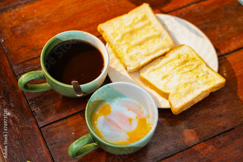 A ready-to-eat breakfast set that includes black coffee, poached eggs, and two slices of brown butter toast.
