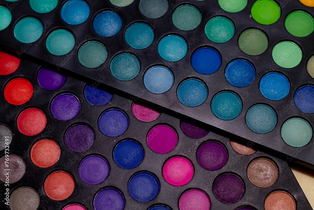 Closeup of a vibrant eyeshadow palette featuring a variety of colorful hues and shades. Closeup of a vibrant eyeshadow palette featuring a variety of colorful hues and shades.