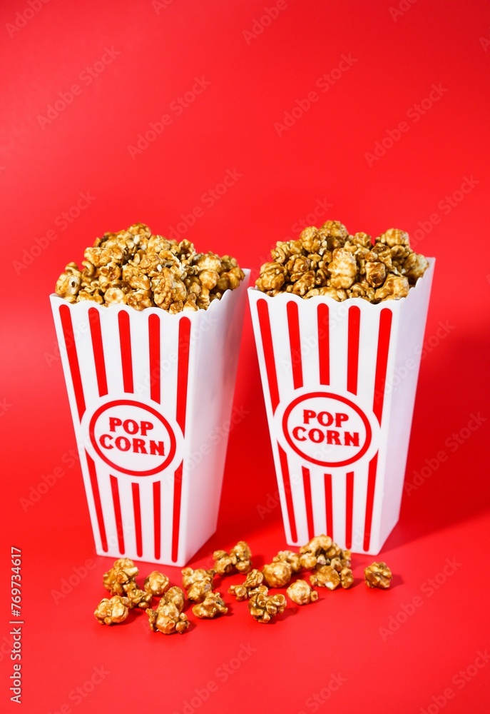 Vertical shot of sweet caramel popcorn in traditional striped boxes