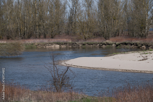 Meandrująca rzeka podmywa linie brzegową, erozja brzegu rzeki 