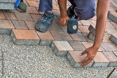 Construction worker repairing a brick wall in an outdoor area
