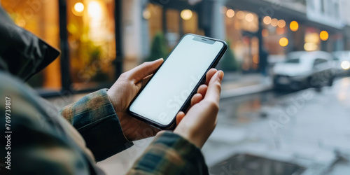 A person holding a cell phone in a city street