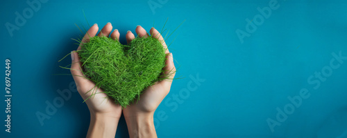Flat lay hand hold world grass in heart shape , World environmental , Earth day ,Save the earth.
