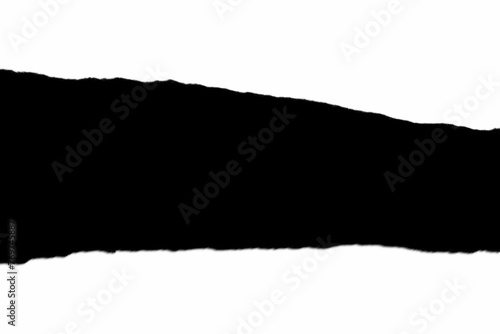 Black, torn cardboard piece isolated on a white background, illuminated by natural light