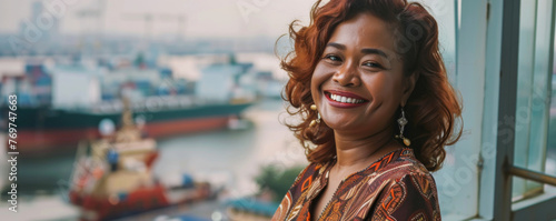 Smiling Indonesia woman looking at camera while standing in front of container ship

