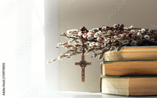 christian rosary cross, biblical books and willow branches on table, abstract light background. Orthodox palm Sunday, Easter holiday. Symbol of Christianity, Lent, Faith in God, Church. copy space