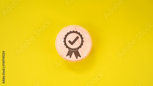 Quality warranty icon on wooden tube on yellow background. Used for banners and advertising product and service quality commitments.