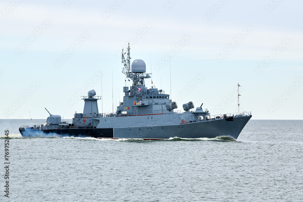 Russian warship armed with armament sails into sea toward military target to attack and destroy enemy, military ship performing strategic maneuver, Russian sea power deployment for tactical advantage