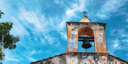 A close-up of a church bell tower against a backdrop of blue sky.