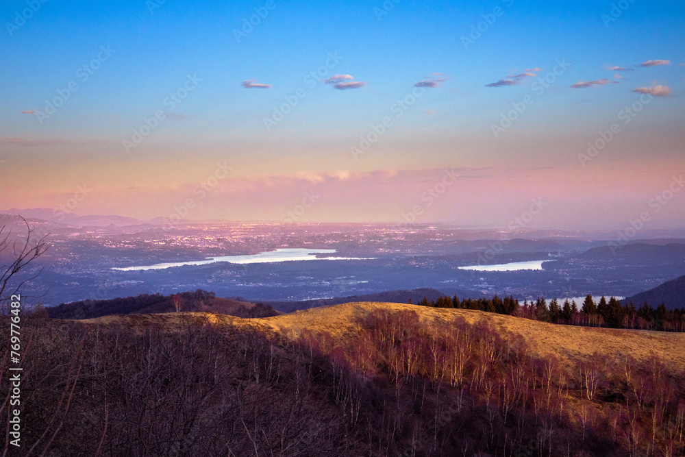 Warm colors at sunset. Suggestive winter landscape, with hills illuminated by the rays of the falling sun. Lakes in the background.
