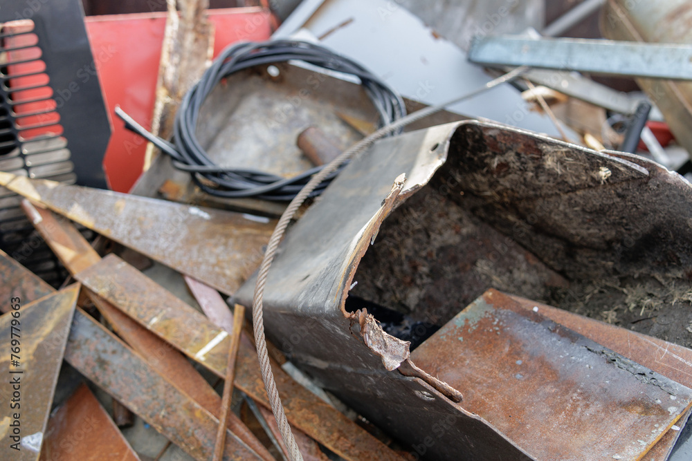 In a close-up photograph, abandoned metal waste litters a scrap yard, portraying the industrial decay and neglect characteristic of such environments.