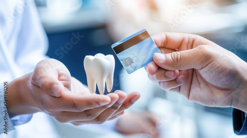 A person's hand holding a white 3D model of a molar extends to another hand holding credit card, symbolizing a financial transaction for dental services. Paid medical services, dental business photo