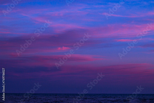 Beautiful clouds in a colorful sky at sunset in summer over the sea
