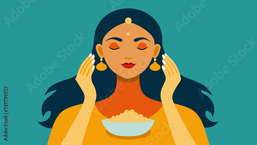  A womans hands applying a thick paste of cleansing chickpea flour and turmeric to her face a common Ayurvedic beauty ritual for purifying the