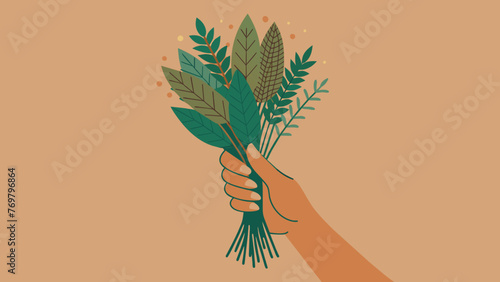  A hand holding a bundle of dried herbs with intricately woven patterns visible on the leaves.