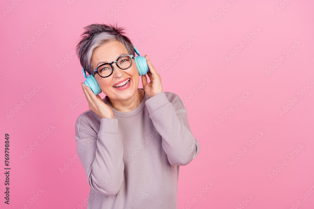 Photo of positive cheerful woman wear trendy clothes listen mp3 player songs empty space isolated on pink color background Photo of positive cheerful woman wear trendy clothes listen mp3 player songs empty space isolated on pink color background