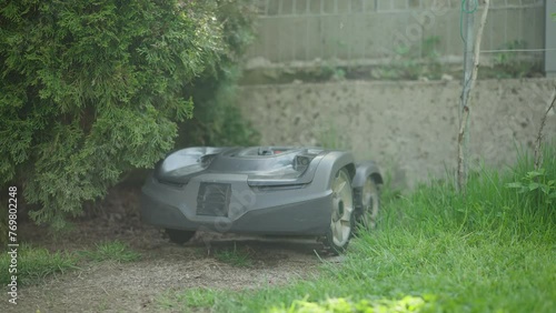 Still shot - Robotic lawn mower docking on charge station to fill up the batteries for another mowing session