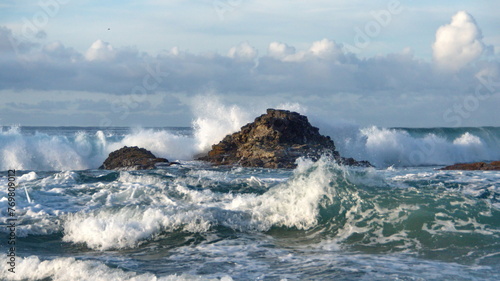 Waves breaking around rocks just off the beach in Zipolite, Mexico