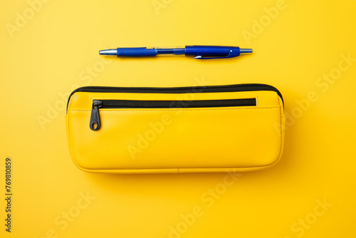 Trousse d'école jaune. Concept de rentrée scolaire, trousse à crayons et fournitures scolaires. Vue de dessus fond jaune.