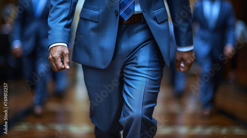 Close-up of businessmen walking in suits, focus on movement and professional attire, concept of corporate lifestyle.