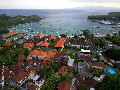 Aerial Footage of Padang Bai Village in Bali Indonesia. Fisherman Village. Balinese Houses. Parked Boats in the harbor. photo