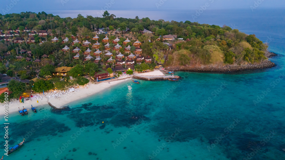 Beach villas at Long beach of Koh Phi Phi island, Krabi, Thailand. Tropical paradise white sand beach with turquoise waters of Andaman sea, aerial view at sunset.