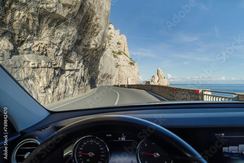 Driving on a coastal road winding along a cliff