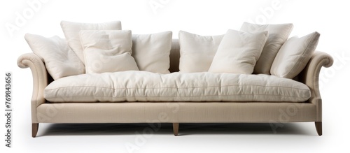 A beige studio couch with white pillows, providing comfort and style to any room. The rectangular sofa bed contrasts beautifully with the grey flooring in this contemporary setting