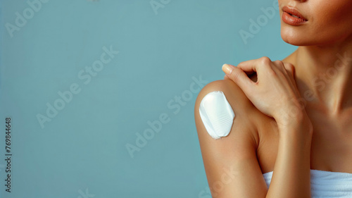 A woman is applying lotion to her arm