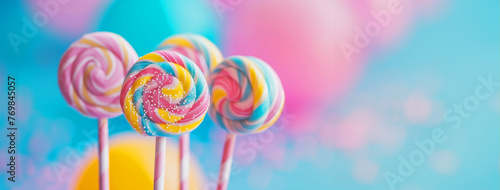 A group of colorful lollipops are arranged in a row on a blue background. The lollipops are of different colors and sizes, and they are placed in a way that they look like they are standing upright