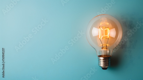 Minimalistic Light Bulb Hanging Against a Blue Background