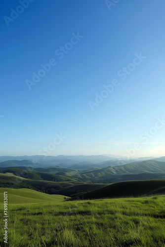 Verdant hills roll under a clear sky, their curves casting soft shadows in the gentle light.