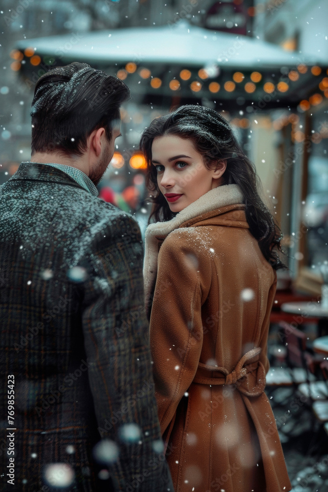 A man and a woman in formal clothes walking down the street in a snowfall A man and a woman in formal clothes walking down the street in a snowfall