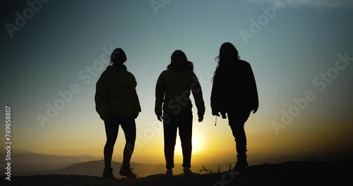 Three sihouettes of young girls jumping in the mourning photo