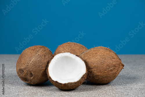 Coconuts on blue background, space for text